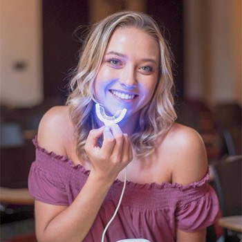 Young woman holding Glo teeth whitneing appliance