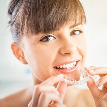 Woman placing Invisalign tray