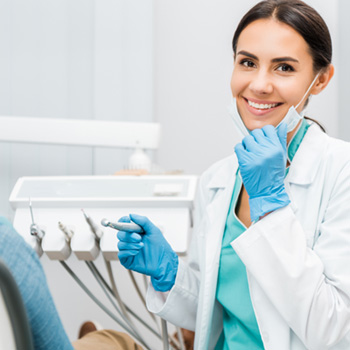 Dentist smiling with patient in treatment room