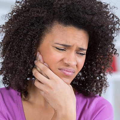 Woman holding jaw in pain