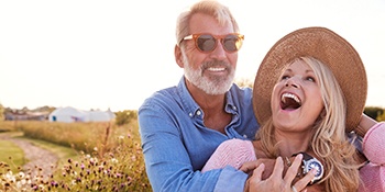 A middle-aged couple showing off their new dental implants in Phillipsburg