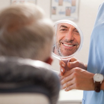 dentist holding mirror for patient