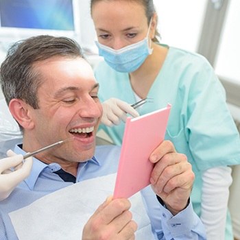 Man admiring his new dental implants in Phillipsburg