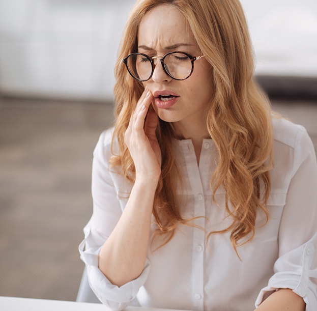 Woman holding jaw in pain