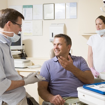 Man in dental chair talking to dentist