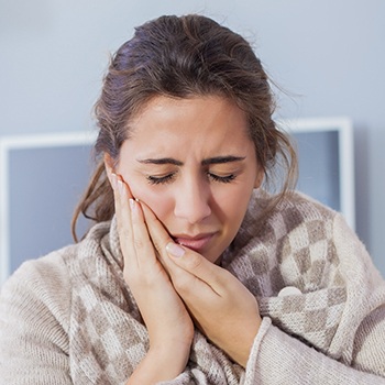 Woman holding jaw in pain