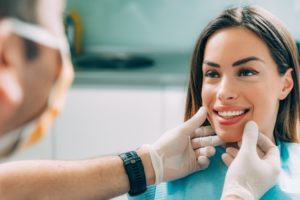 a woman smiling at the dentist after a non-invasive cosmetic treatment