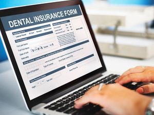 Filling out a dental insurance form on a laptop