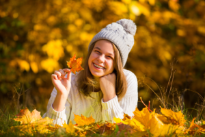 a girl smiling in a park during autumn