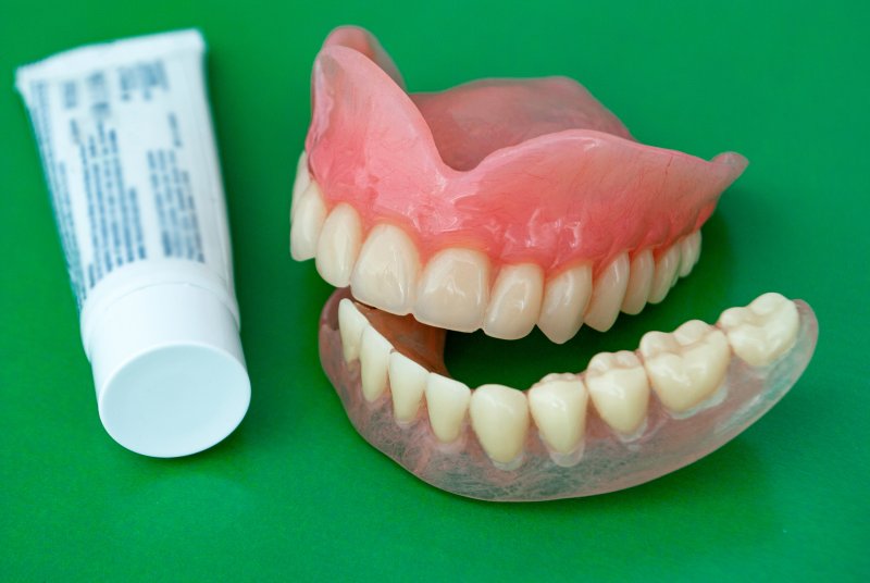 A pair of dentures and denture adhesive