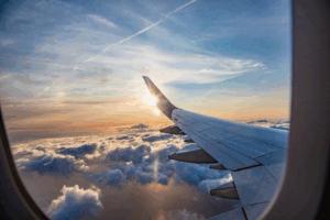 Looking out of an airplane window to see the wing and sunset